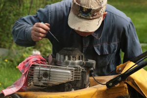 man fixing a mower