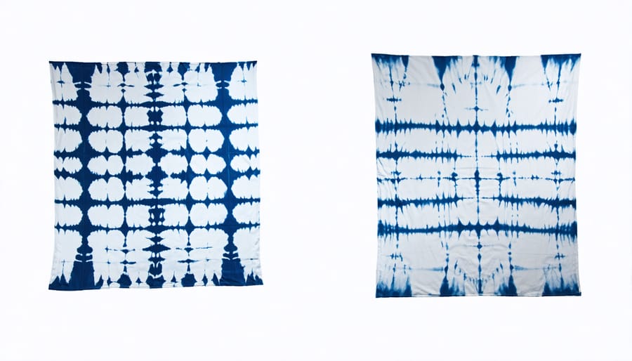 Hands demonstrating traditional Shibori fabric folding patterns